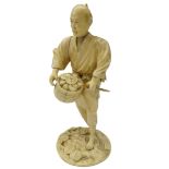 Japanese Meiji period carved ivory figure of a Farmer dressed in a robe, holding a basket and stick,