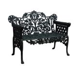 Victorian style cast iron garden bench, with ornate leaf back and lattice arms on scroll feet,
