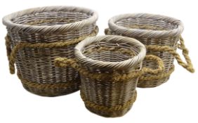 Three graduating wicker log baskets with rope work handles,