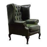 George lll style wing back armchair upholstered in deep buttoned green leather on cabriole supports,