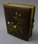 Victorian photograph album, leather bound with painted foliage, gilt edges and brass clasp,