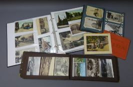 Three albums containing over four hundred and eighty Edwardian and later postcards including real