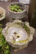Two circular composite stone low garden urns,
