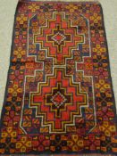 Baluchi red ground rug, two medallions, repeating border,