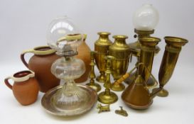 Three matching partly glazed graduated terracotta jugs, brass oil lamp,