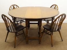 Set four Ercol medium elm hoop back chairs (W43cm) and an oval oak drop leaf dining table,
