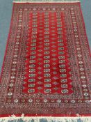 Bokhara red ground rug, geometric pattern field, repeating border,