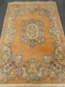 Chinese pink ground woollen rug, central floral medallion,