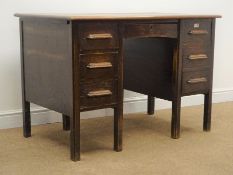 1930's oak twin pedestal desk, single central frieze drawer flanked by six graduating drawers,