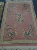 Chinese pink ground wool rug, field decorated with dragons,