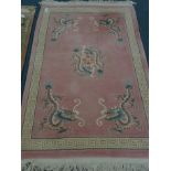 Chinese pink ground wool rug, field decorated with dragons,