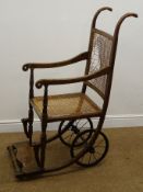 Early 20th century beech wheel chair, cane back and seat,