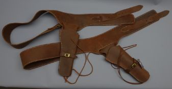 Two brown leather single gun rigs, plain stitched belts with brass buckles,