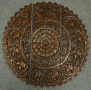 Eastern three section circular carved wall hanging, central flower motif,