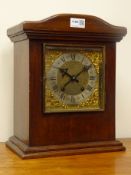 Early 20th century serpentine top walnut mantel clock, square brass dial with bevelled glass door,