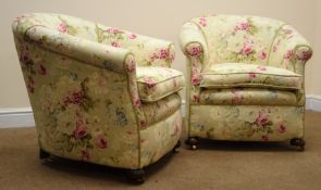 Pair of Edwardian floral upholstered tub chairs on bun feet with recessed brass castors,