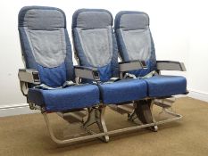 Row of three aircraft seats upholstered in a blue fabric,