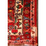 Persian style red ground rug, three central medallions, repeating border,