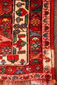 Persian style red ground rug, three central medallions, repeating border,
