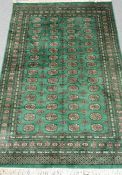 Bokhara green ground rug, geometric patterned field,