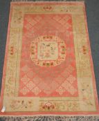 Pink ground Chinese rug, central medallion depicting two birds, repeating border (184cm x 128cm),