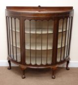 Early 20th century mahogany demi-lune display cabinet, raised back with shell carving,