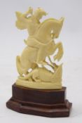 Early 20th century carved ivory figure of Saint George and the Dragon on hardwood stand,