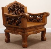 Heavily carved Eastern hardwood armchair depicting elephants and trees,