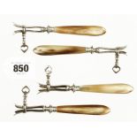 An unusual set of 4 miniature French horn handled clamps similar to the larger ham bone holders,