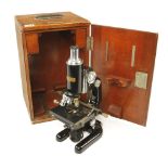 A black enamelled microscope by BUSCH Rathnow with three lenses,