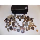 Miscellaneous world coins and a small wood cabinet.
