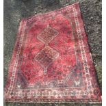 A Shiraz rug, South West Persia, the madder field with two linked charcoal medallions, with animals,