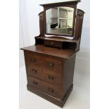 An Arts and Crafts oak wardrobe and matching dressing table, with copper mounts,