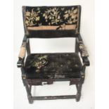 A Cromwellian style black painted open armchair, with a floral decorated embroidered back and seat,