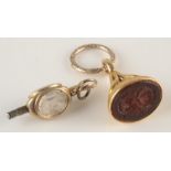 A gold seal, the carved hard stone with co-joined intaglio crests on chased gold split ring,