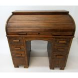 An oak roll top pedestal desk, early 20th century, the tambour slide enclosing a fitted interior,