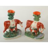 A pair of Victorian Staffordshire cow and calf spill groups, height 27.5cm.