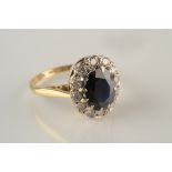 A diamond and sapphire oval cluster ring set in 18ct yellow gold.