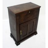 A George III oak cupboard, with a lift up lid above a panelled door, height 82cm, width 63cm,