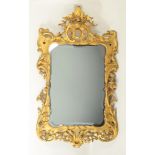 A George lI finely carved and gilt wall mirror in rococo taste. 146 x 84cm.