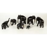 A set of seven graduated ebonised elephants, height of largest 16cm.