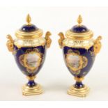 A pair of Coalport blue ground twin handled lidded vases the front of each with a topographical