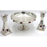 A pair of contentious Arts and Crafts silver plated candle sticks, possibly by Liberty,