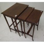 An Edwardian mahogany nest of three tables, each with a satinwood crossbanded top on splay legs,