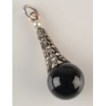 A black onyx ball pendant, it hangs from a diamond set articulated cone and a single pearl.
