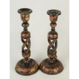 Two Kashmiri lacquered candlesticks, each with floral decoration and open twist stems,