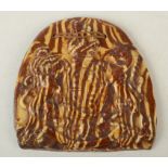 An unusual redware tablet moulded with royal arms and covered with agate slip glaze.