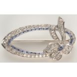 A white gold diamond set elliptical bow brooch tied with a bow,