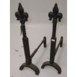 A pair of wrought iron andirons, with fleur de lis twist finials, height 57cm.