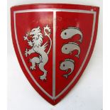 An Heraldic red painted metal shield, depicting a silver lion and three stylised fish, 58 x 55cm.